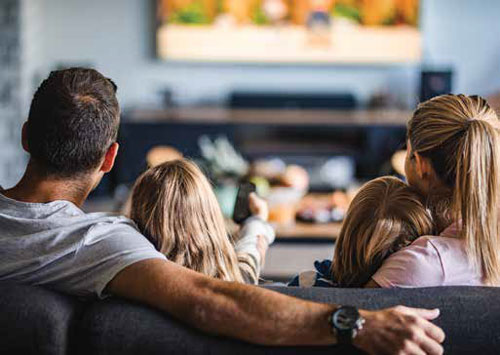 A family enjoying smart home features during movie night in Calgary, Alberta.